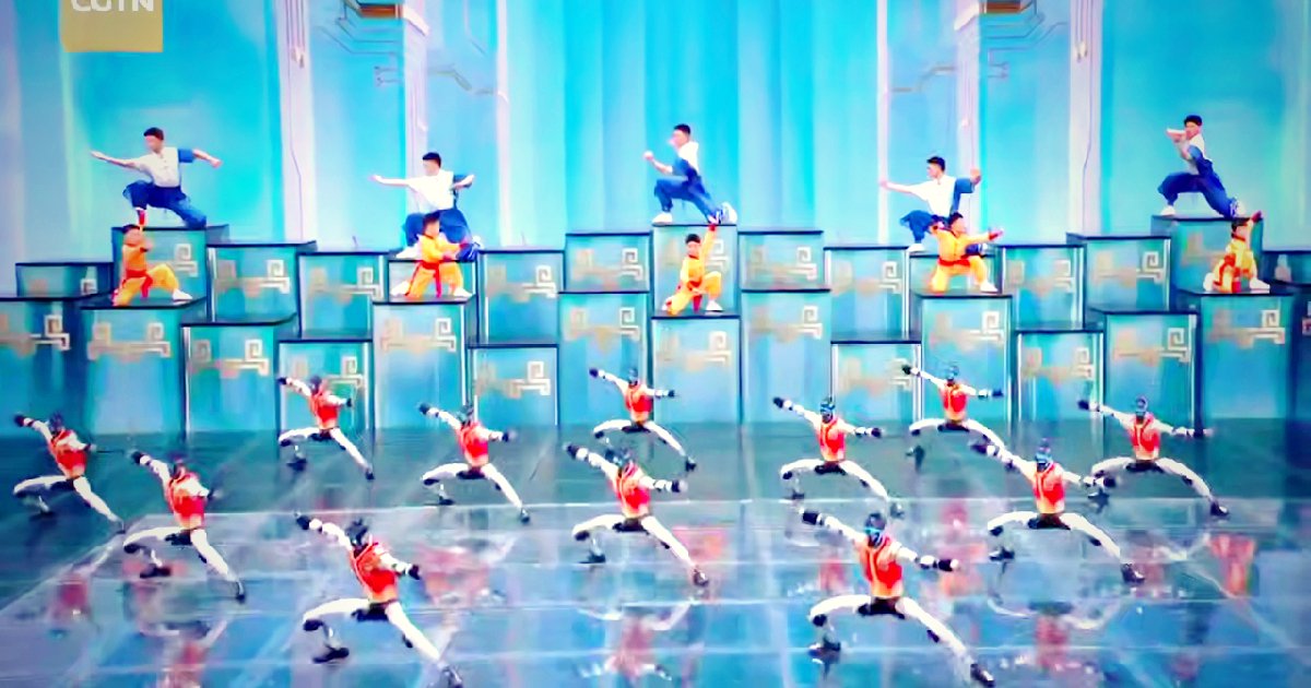 Humanoid robots performing kung fu on a stage during a televised gala