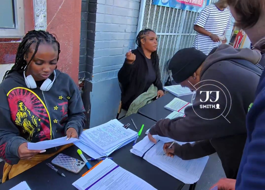 People lining up to sign petitions on a street corner in San Francisco