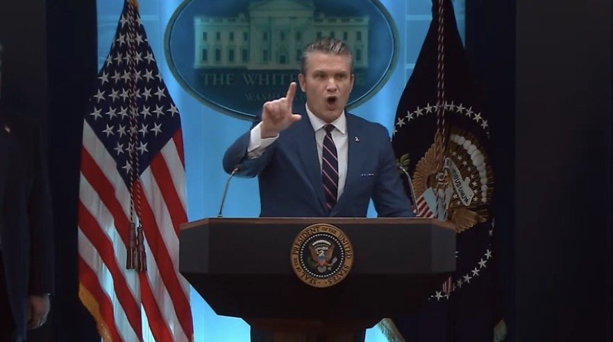 Pete Hegseth speaks beside President Trump during a press conference on Iran