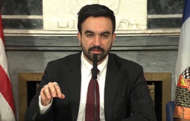 Zohran Mamdani speaking at a podium in New York City