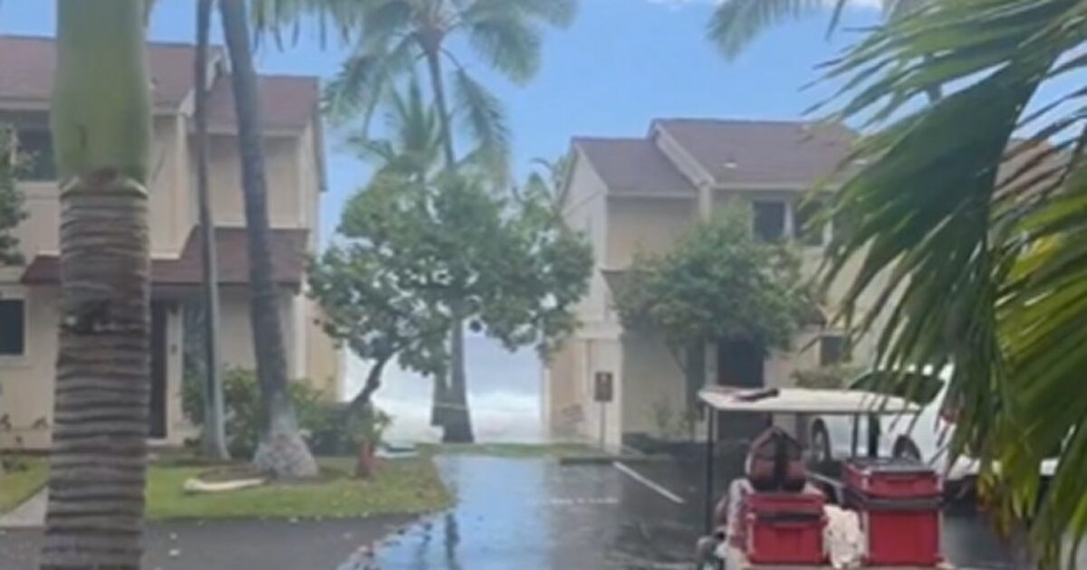 Massive wave crashing over an oceanfront condo roof in Keauhou, Hawaii