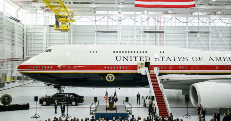 Air Force One on a runway with security personnel nearby